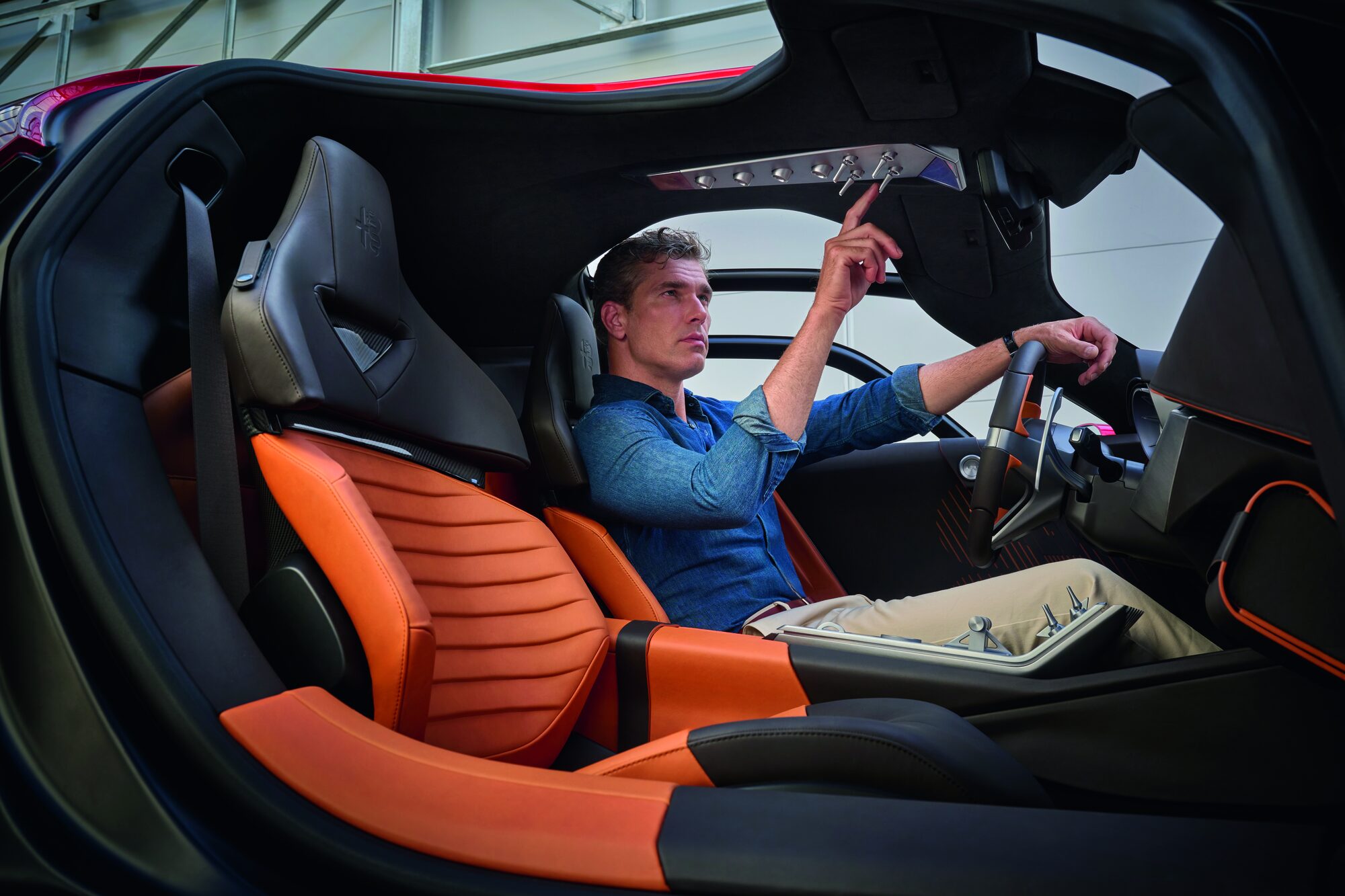 Driver at the wheel of the Alfa Romeo 33 Stradale, seats upholstered in cognac Pelle Frau® leather