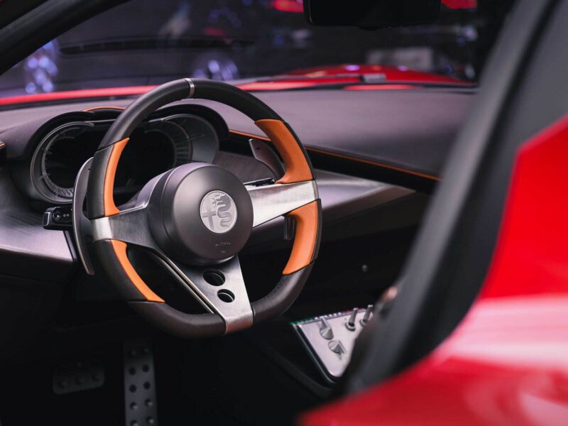 Black and orange steering wheel and dashboard detail of the Alfa Romeo 33 Stradale
