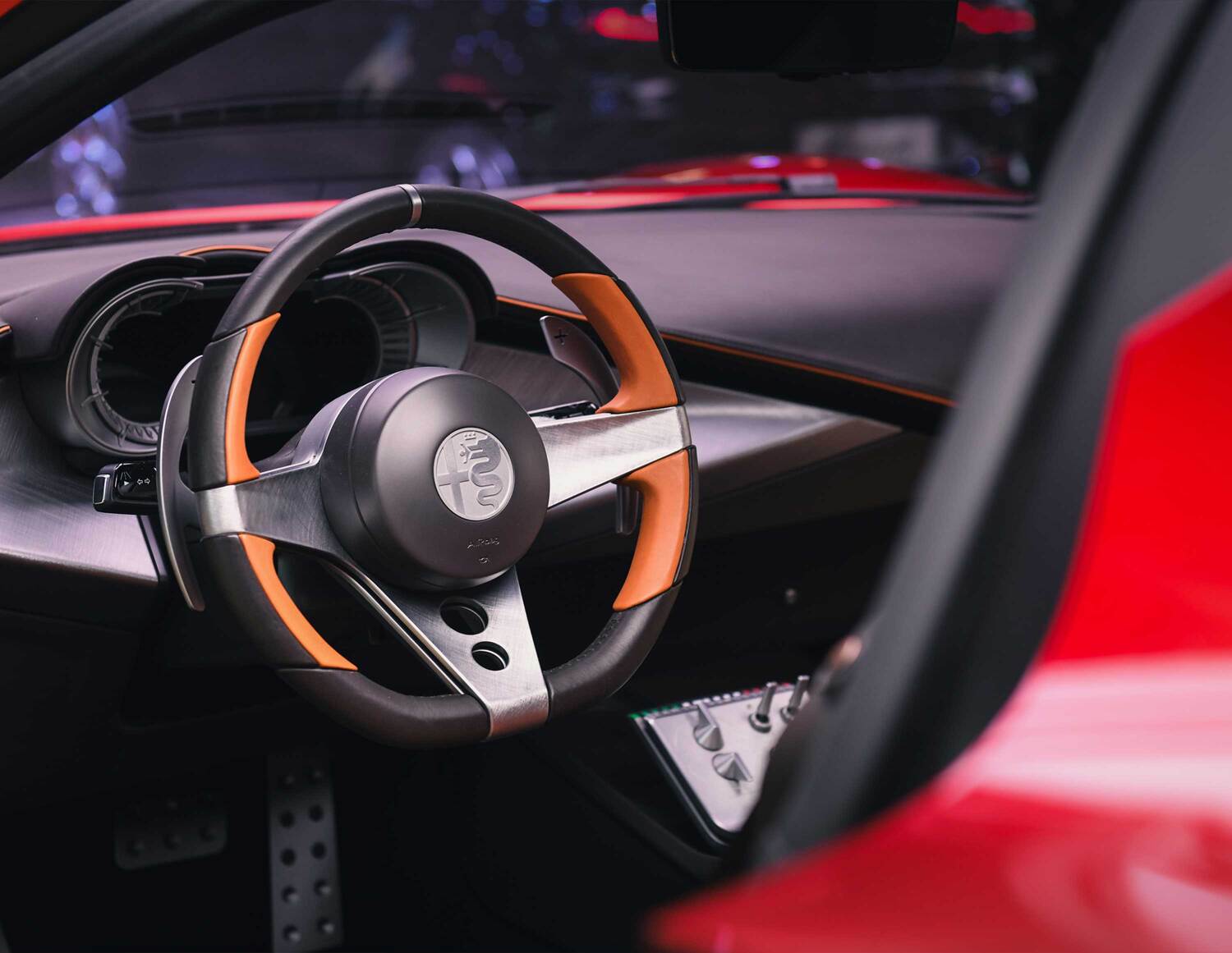 Black and orange steering wheel and dashboard detail of the Alfa Romeo 33 Stradale