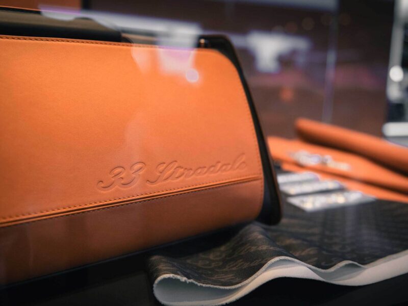 Embossed logo detail on the orange leather trim of the Alfa Romeo 33 Stradale