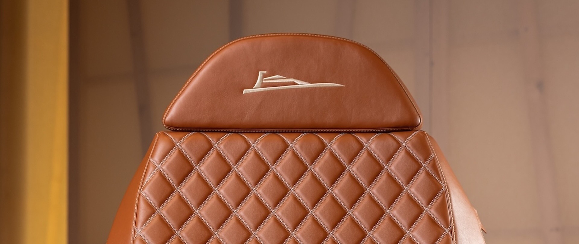 Detail of a cognac leather boat seat headrest embroidered with the Nautheos logo