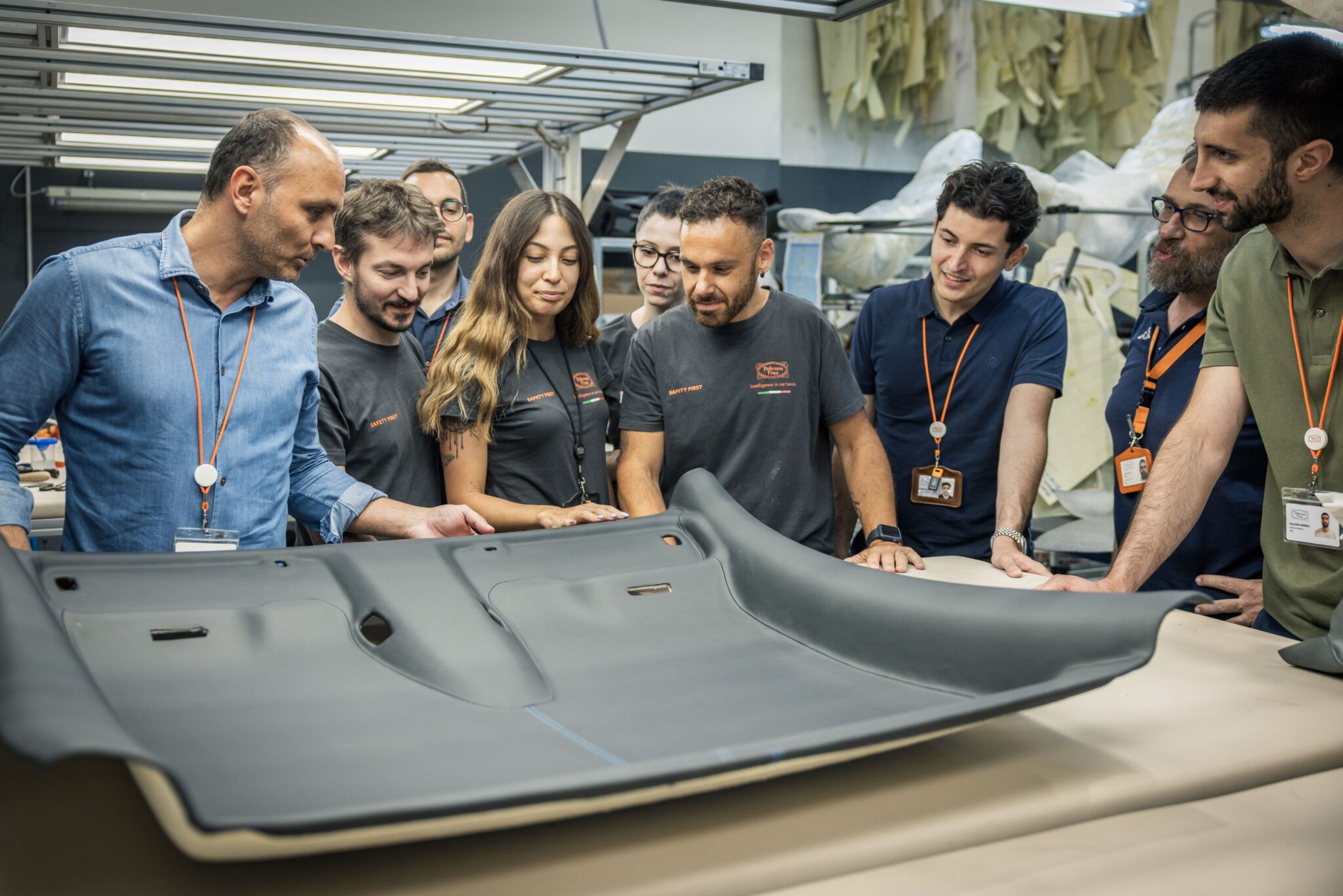 Gruppo di persone che esamina un componente stampato in pelle e supporto tecnico in laboratorio