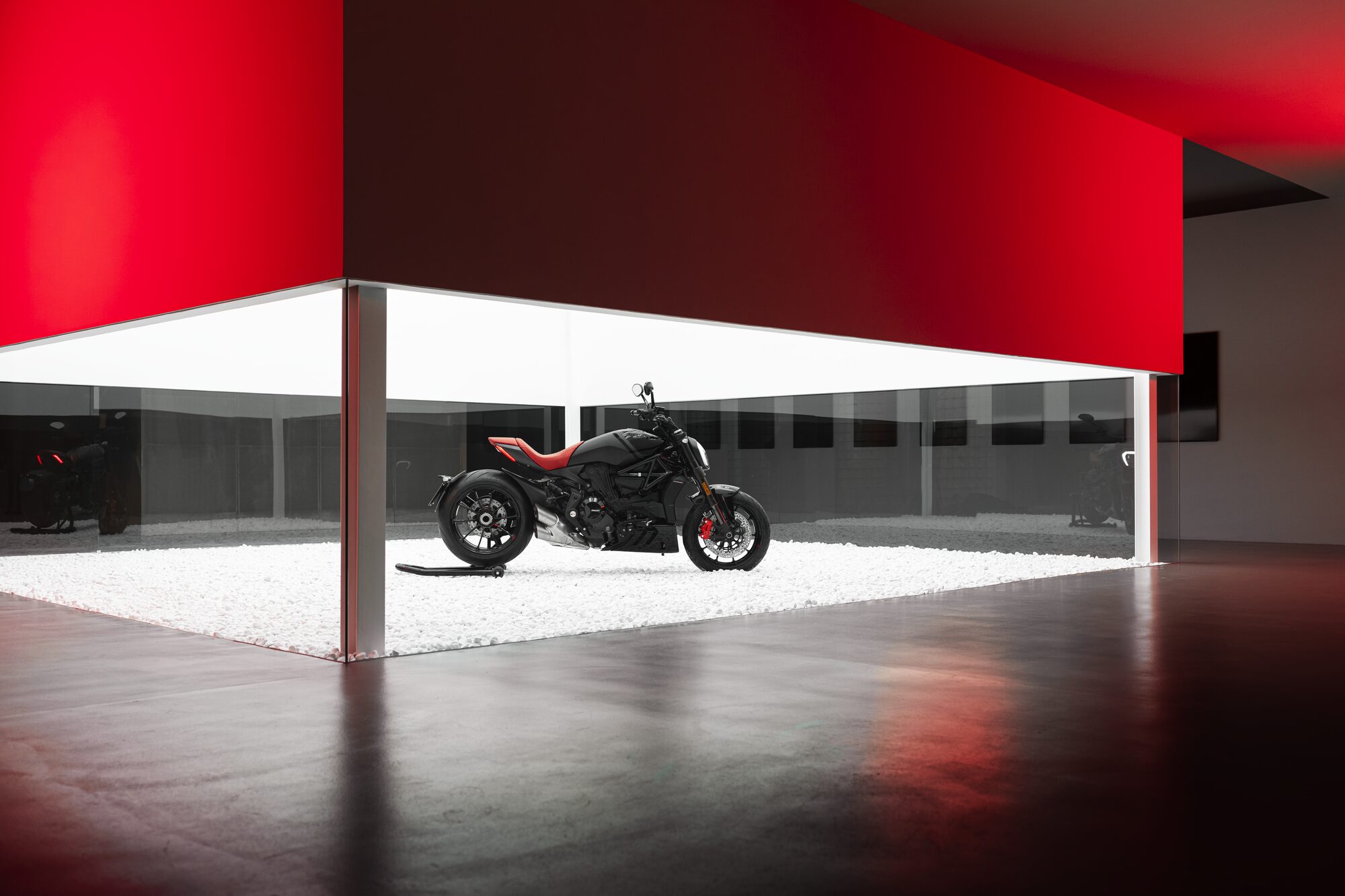 Ducati XDiavel motorcycle on display in a showroom with red and white geometric architecture