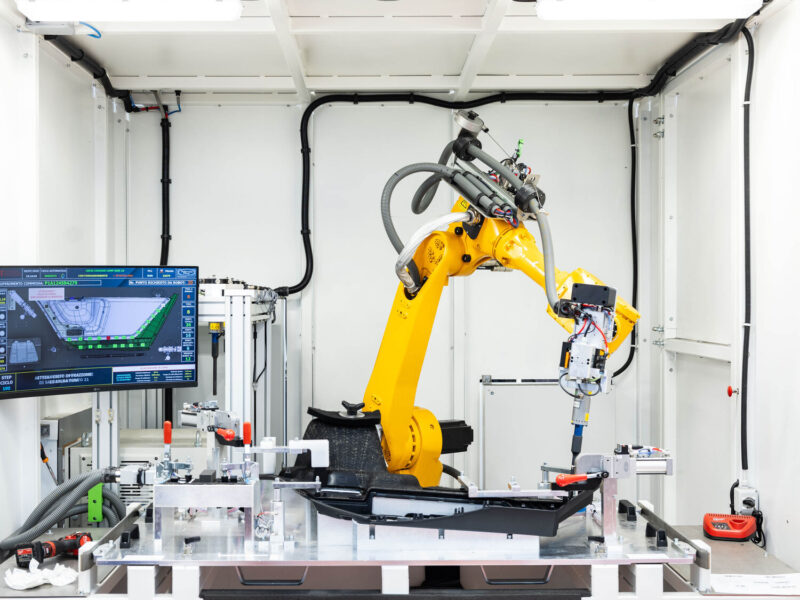 Robotic arm operating inside a Poltrona Frau production cell