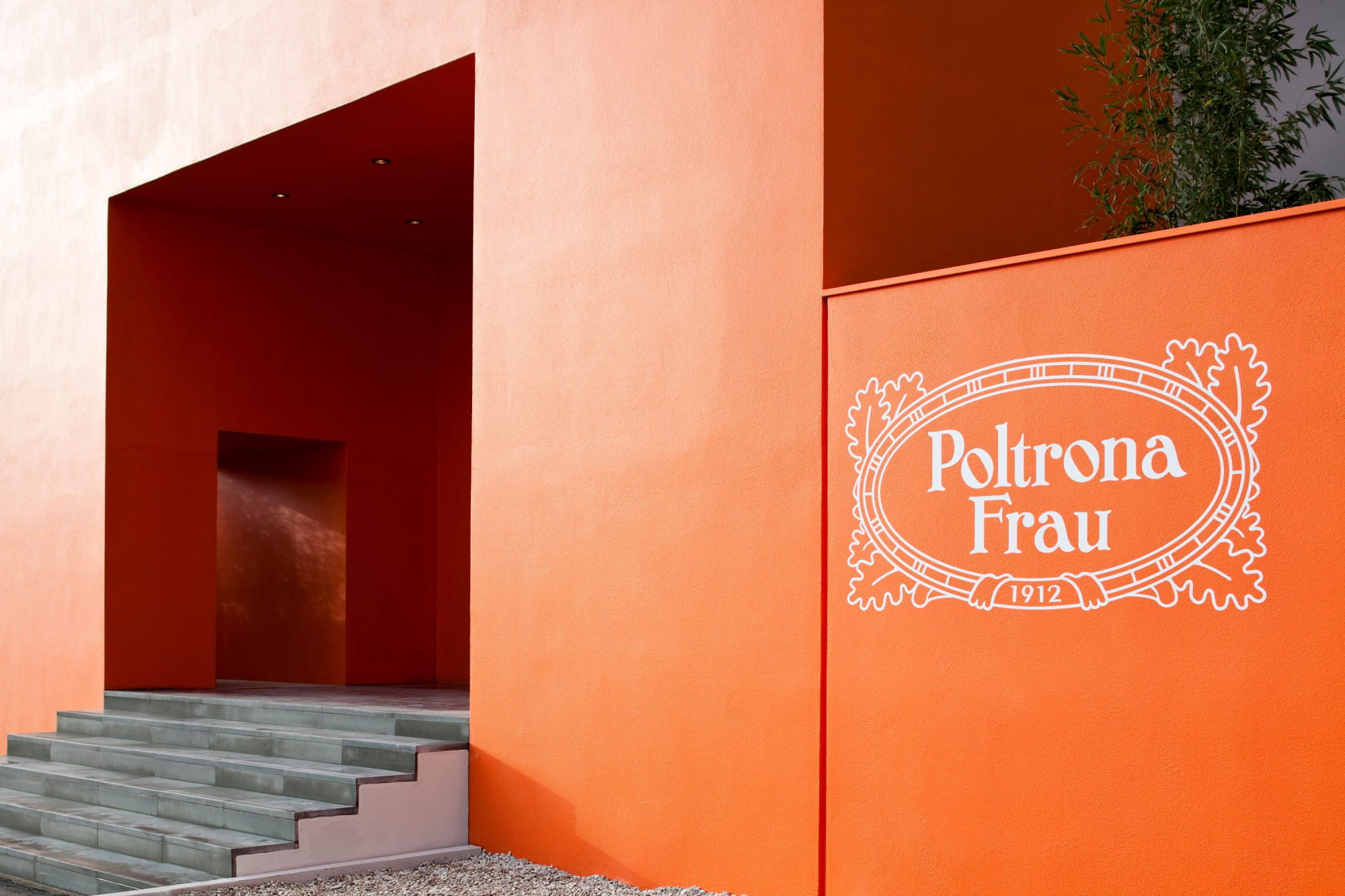Ingresso rosso del Museo Poltrona Frau con l'insegna del marchio