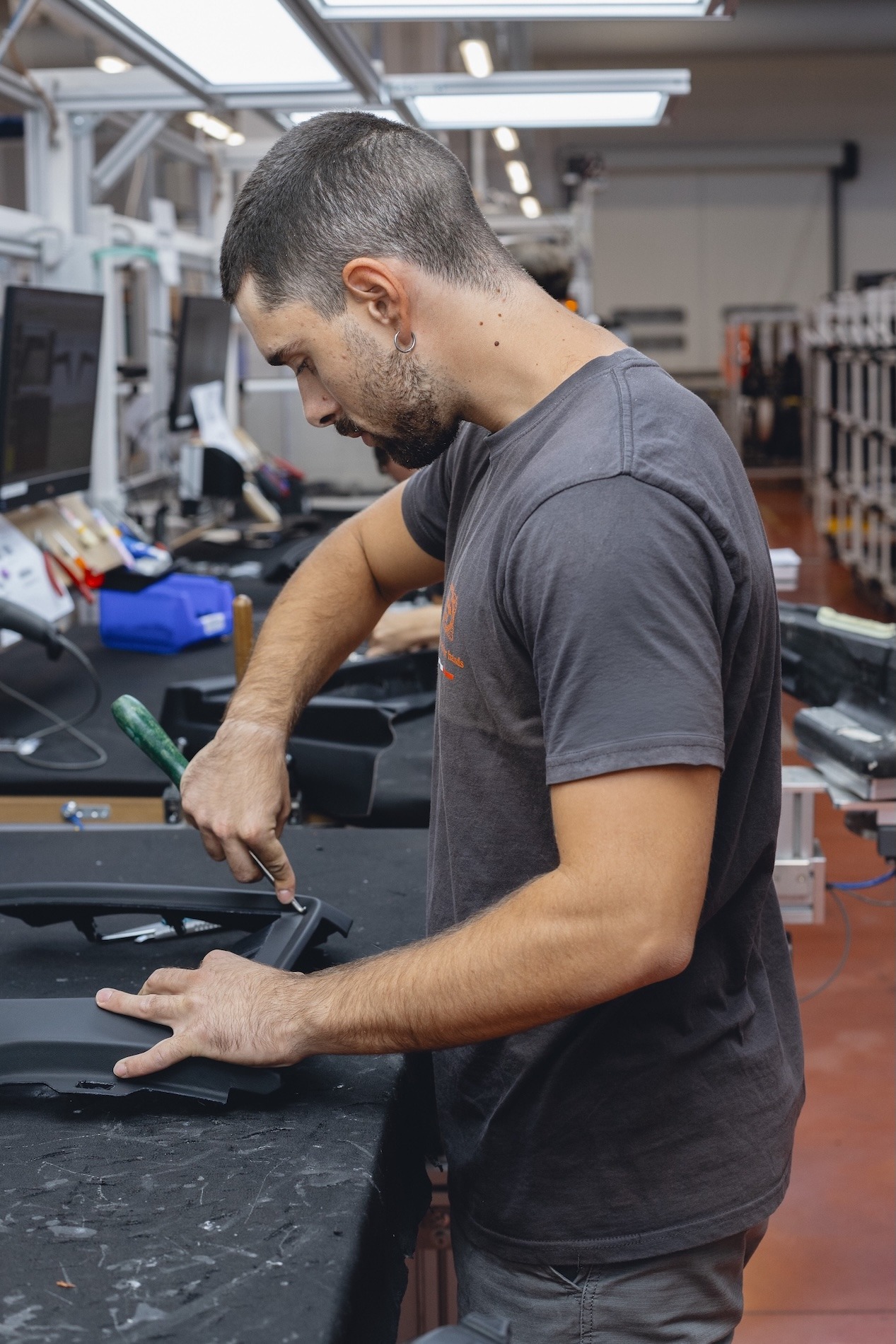 Craftsman shaping a leather component by hand in the workshop