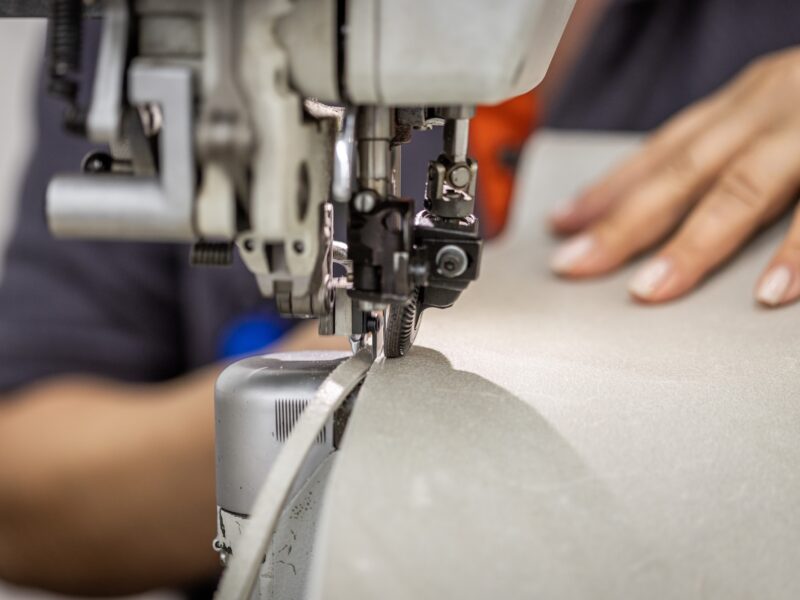 Close-up of an industrial sewing machine stitching leather