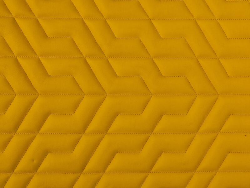 Detail of yellow leather with chevron quilted stitching