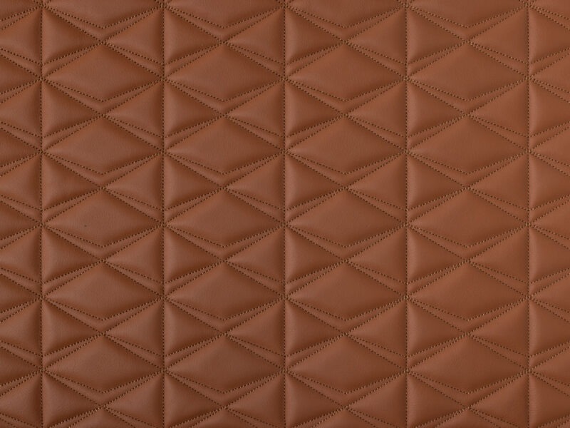Detail of terracotta leather texture with quilted triangular stitching