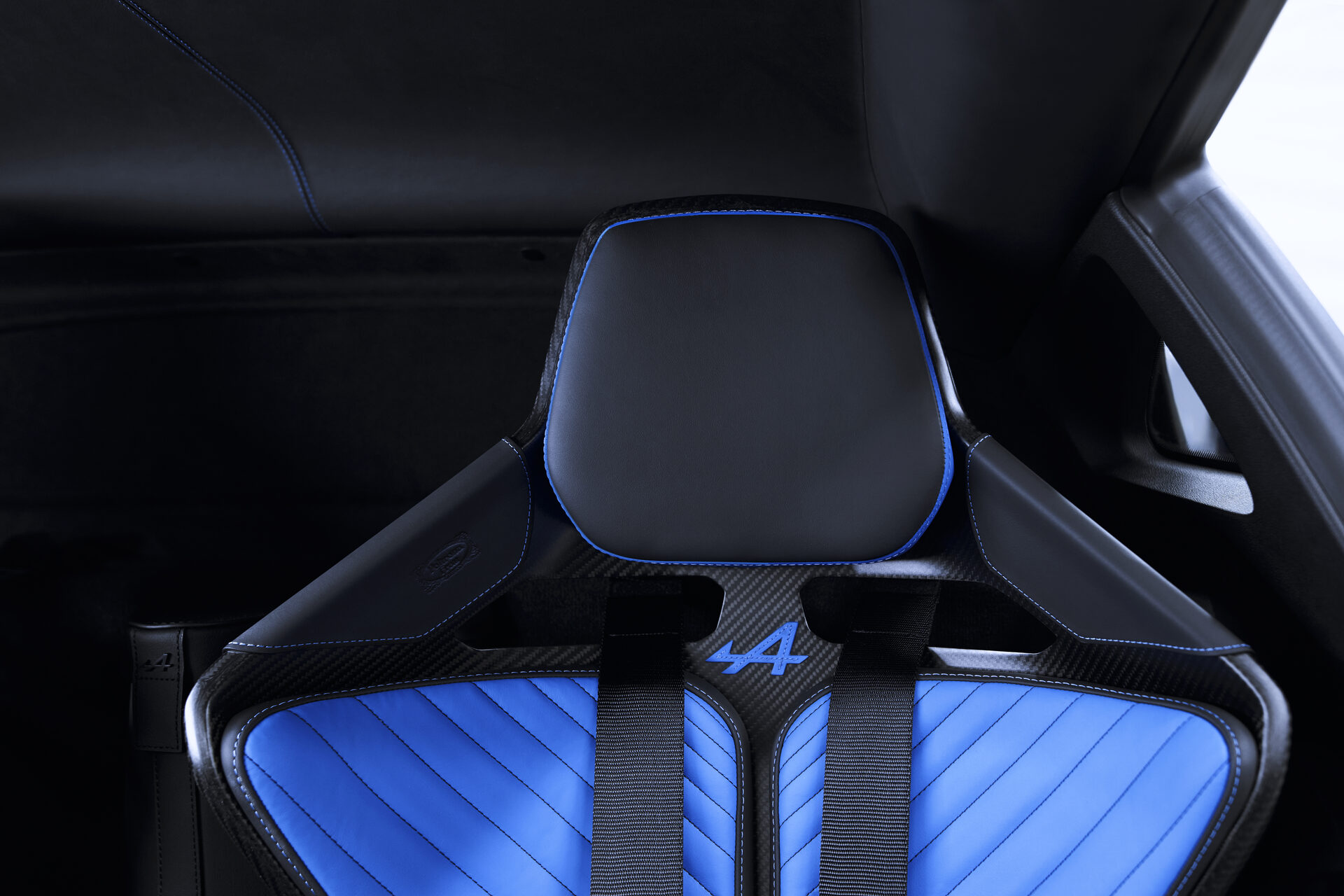 Detail of the black leather headrest with blue edging on the carbon fiber seat shell