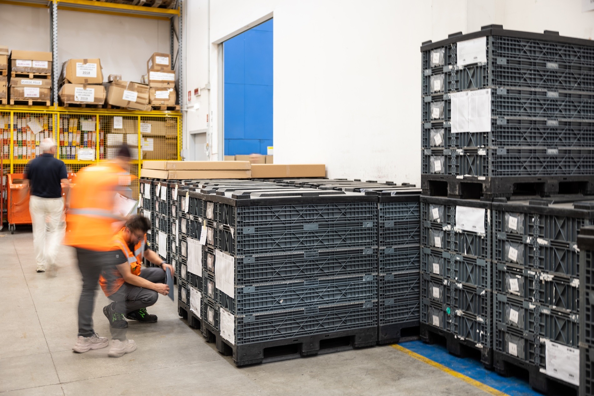 _P6A2070 Worker inspecting stacked reusable plastic crates in the Poltrona Frau In Motion production warehouse