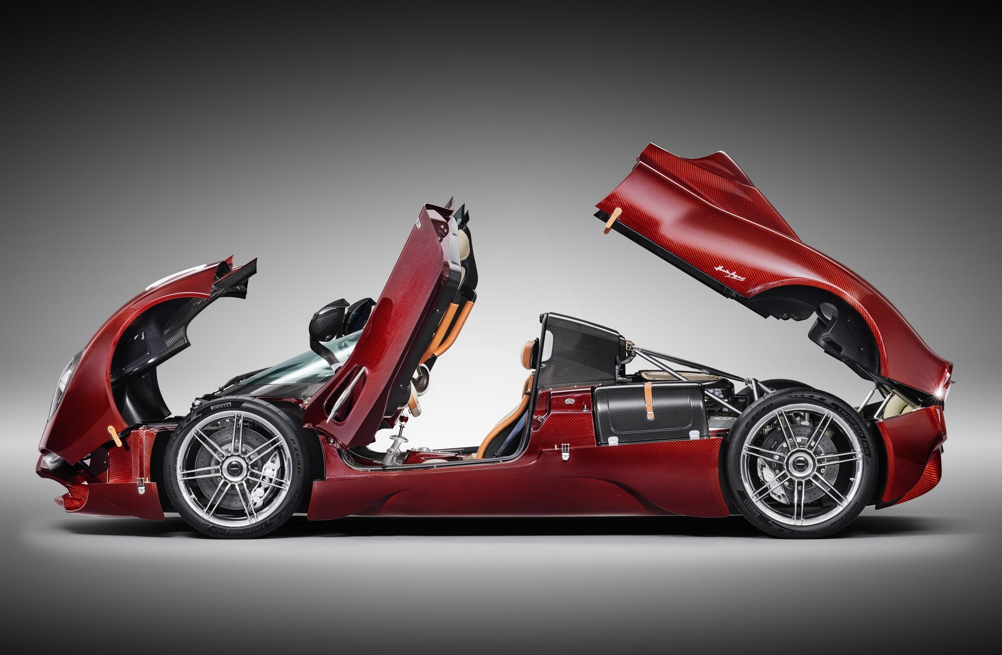 Side view of the Pagani Utopia Roadster with doors and hoods open, revealing the carbon fibre structure