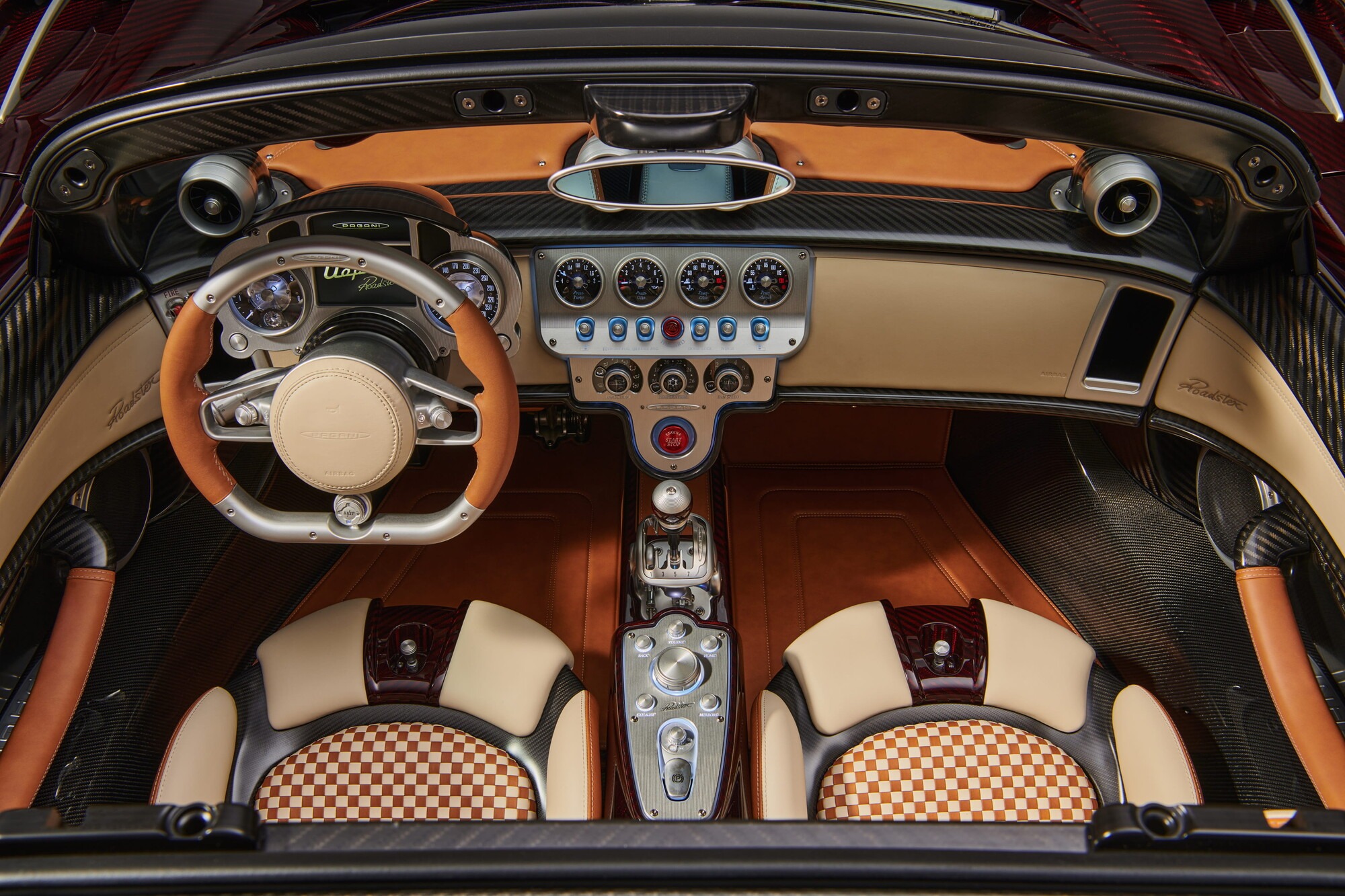 Overhead view of the Pagani Utopia Roadster interior, dashboard and two-tone leather seats with a checkered pattern